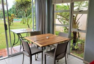einen Holztisch und Stühle in einem Zimmer mit Fenster in der Unterkunft 28 and 29 The Bridge in St Lucia