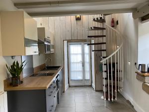 a kitchen with a staircase leading to a door at Ostalon de Sénégats in Lacaze