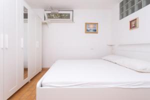 a bedroom with a white bed and a window at N91 - Numana, nuova taverna bilocale in Numana