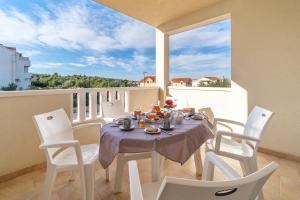 a dining room with a table and chairs on a balcony at Villa Ankora in Supetar