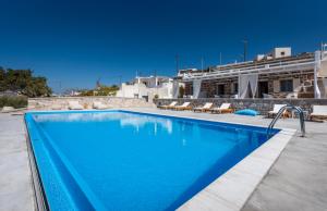 a swimming pool with blue water in front of a building at Anemi Suites in Adamantas