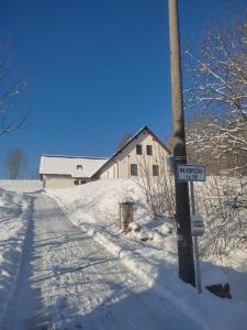 a street sign on a pole in the snow at Na Kopečku apartmány in Cerny Dul