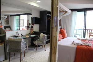 ein Schlafzimmer mit Bett und Schreibtisch und eine Küche in der Unterkunft Resort Marulhos Porto de Galinhas in Porto De Galinhas + 35 Fotos
