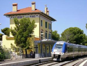 un tren en las vías frente a una estación de tren en Studio Sausset Madura, en Sausset-les-Pins