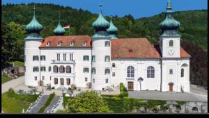 duży biały budynek z kopułami na górze w obiekcie Pension Artstetten w mieście Artstetten