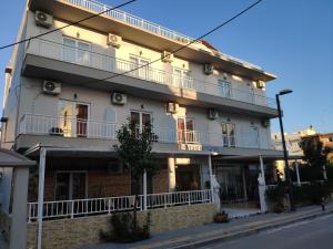 un gran edificio blanco al lado de una calle en Marie Hotel, en Cos