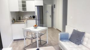 a kitchen with a white table and a white couch at Caminando al Guggenheim by Urban Hosts in Bilbao