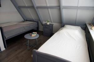 1 dormitorio pequeño con 2 camas y mesa en 8 Langebaen uitwellingerga sneek, en Uitwellingerga