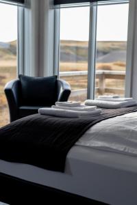 - une chambre avec un lit, une chaise et une fenêtre dans l'établissement Afternoon Cottages, à Hella