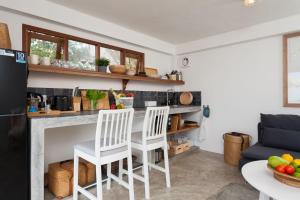 - une cuisine avec 2 chaises blanches et un comptoir dans l'établissement Cape Shark Villas, à Koh Tao