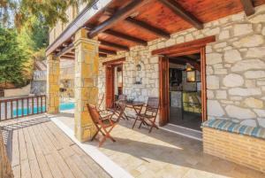 a stone house with a patio with a table and chairs at Eleni Vassilikos Zakynthos in Xirokástellon