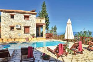 a house with a swimming pool with chairs and an umbrella at Eleni Vassilikos Zakynthos in Xirokástellon