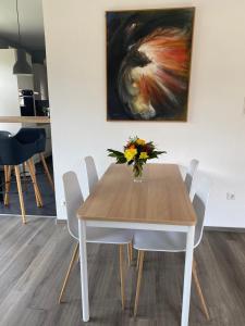 uma mesa de jantar com um vaso de flores em Ferienwohnung Bienengarten em Bingen am Rhein