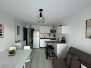 eine Küche und ein Wohnzimmer mit einem Sofa und einem Tisch in der Unterkunft Appartement Les Pieds dans l'eau in Collioure