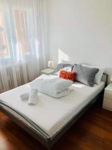 a bed with pillows on it in a bedroom at LOVELY apartment near Iulius TOWN - Biggest Shoping Center IP19 in Timişoara