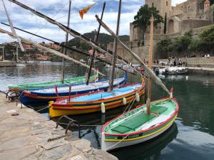 three boats are docked in the water near a castle at Appartement Les Pieds dans l'eau in Collioure