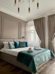 a bedroom with a large bed with blue pillows at Von Cruss apartments in Lviv in Lviv