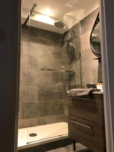 a bathroom with a shower with a glass door at Les marinas vue Mer in Deauville