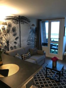 a living room with a couch and a table at Les marinas vue Mer in Deauville