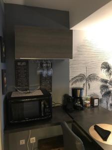 uma cozinha com um micro-ondas e comodidades para preparar café num balcão em Les marinas vue Mer em Deauville