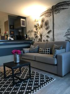 a living room with a couch and a table at Les marinas vue Mer in Deauville