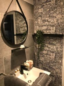 een badkamer met een spiegel en een witte wastafel bij Les marinas vue Mer in Deauville