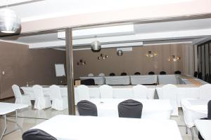 a conference room with white tables and white chairs at Vahlavi Lodge in Giyani