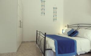 una camera con un letto e una coperta blu di B&B Le Vele a Maruggio