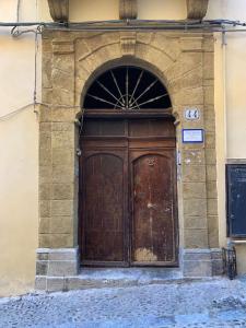 une grande porte en bois sur le côté du bâtiment dans l'établissement Casa vacanza al Duomo: Cefalù, à Cefalù 12 autres photos