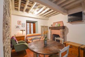 sala de estar con mesa y chimenea en la Casa sull'arco - Albergo diffuso Collelungo, en Collelungo