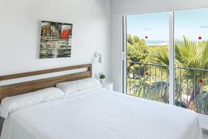 アレナル・デン・カステルにあるSarahの白いベッドルーム(ベッド1台、大きな窓付)