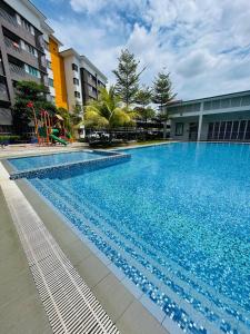 a large blue swimming pool in front of a building at Wallaway2stay Kiara Nilai Apartment 3 Bedroom in Nilai