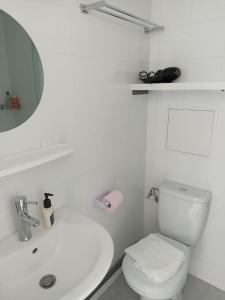 a white bathroom with a toilet and a sink at Studio Vacances château Malo saint Malo in Saint Malo