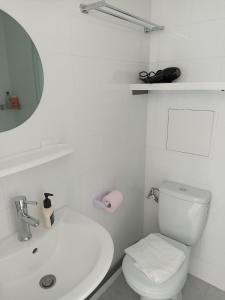 a white bathroom with a toilet and a sink at Studio Vacances in Saint Malo