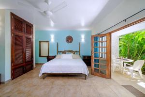 a bedroom with a bed and a table at Beach House Condos, Negril in Negril