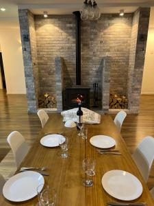 a dining room with a table and a fireplace at Habait ba Shomera in Shomera