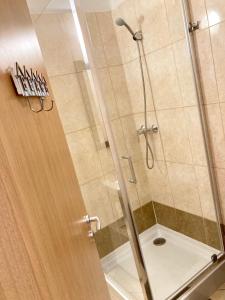 um chuveiro com uma porta de vidro na casa de banho em City Center Apartman Miskolc em Miskolc