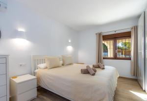 een slaapkamer met een wit bed met 2 kussens erop bij Casa Colina in Jávea