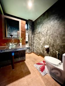 a bathroom with a sink and a toilet in a room at Khao Sok Green Valley Resort - SHA Certified in Khao Sok