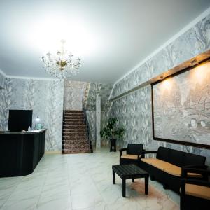 a living room with a chandelier and a staircase at Hotel Дар-Ай in Kostanay