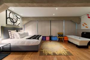 - une chambre avec un lit et une baignoire dans l'établissement Playful Manhattan Style Loft in Downtown Cape Town, au Cap