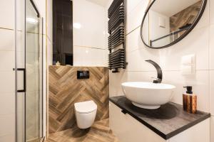 a bathroom with a sink and a toilet at Flatbook - City Center Apartments Waterlane Vintage with Gym in Gdańsk