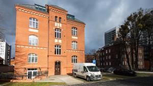a white van parked in front of a brick building at Flatbook - City Center Apartments Waterlane Vintage with Gym in Gdańsk