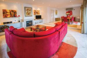 a large red couch in a living room with a fireplace at Two Towers in Vale do Lobo