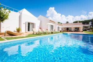 a villa with a swimming pool in front of a house at Two Towers in Vale do Lobo