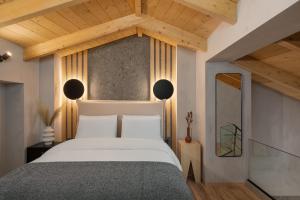 a bedroom with a large white bed with wooden ceilings at Hypnos Cozy Living in Ioannina
