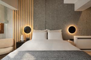a bedroom with a large white bed and a chair at Hypnos Cozy Living in Ioannina