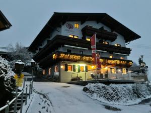 a building with lights on it in the snow at Hotel Wildrose in Neukirchen am Großvenediger