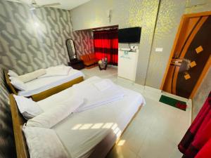 ein Krankenhauszimmer mit 2 Betten und einem Spiegel in der Unterkunft Hotel Aranna Residential in Barpāra