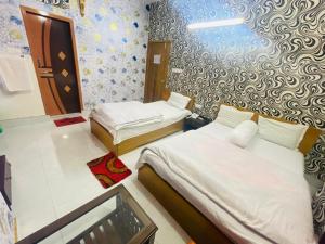 BarpāraにあるHotel Aranna Residentialのベッド2台が備わる壁の客室です。